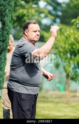 Ein Mann, der ein Spiel Dart spielt. Er braucht Konzentration und Perfektion, um zu gewinnen Stockfoto