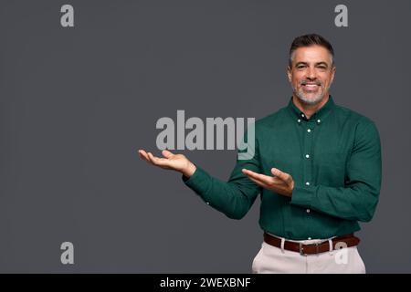Ein lächelnder, reifer Geschäftsmann, der Werbung abseits von Grau zeigt. Stockfoto