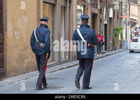 Florenz, Italien - 2. April 2019: Zwei Carabinieri patrouillieren eine kleine Straße der Altstadt. Stockfoto