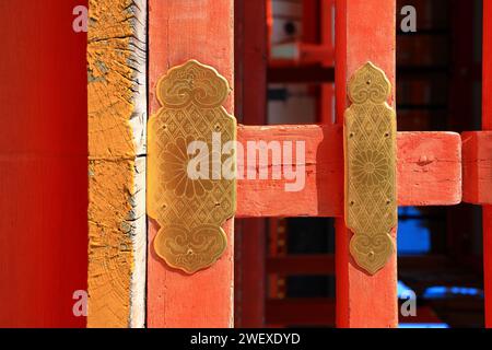 Antiker dekorativer goldener Pfahl am roten Holztor des alten japanischen Tempels. Stockfoto