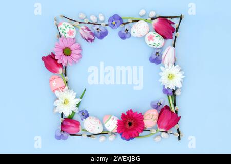 Farbenfrohe Osterhintergrundkante mit dekorierten Eiern, Blumen und Weidenzweigen auf Pastellblau. Minimales natürliches Design für die Weihnachtszeit. Stockfoto