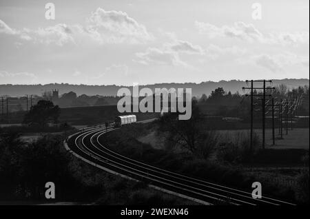 Der Zug der Chiltern Railways Class 168 Clubman fährt über Charlton-on-Otmoor auf der Bicester-Verbindung an einem Teil der Varsity-Eisenbahnstrecke vorbei und fängt den Sonnenuntergang ein Stockfoto