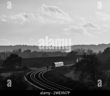 Der Zug der Chiltern Railways Class 168 Clubman fährt über Charlton-on-Otmoor auf der Bicester-Verbindung an einem Teil der Varsity-Eisenbahnstrecke vorbei und fängt den Sonnenuntergang ein Stockfoto