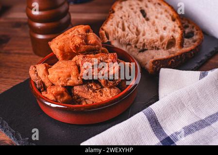 Haufen salzig gebratener Schweineschnecken. Fettes Junk Food. Schweineschnecken auf dem Küchenbrett. Stockfoto