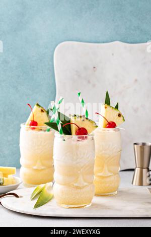 Tropischer Tiki-Cocktail Pina Colada in einem lustigen Glas garniert mit Ananas und Cocktailkirsche Stockfoto