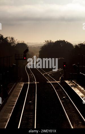 Frühmorgendliches Winterlicht am Bahnhof Bicester North auf der Chiltern-Hauptstrecke mit Eisenbahnlinie und Farblichtsignalen. Stockfoto