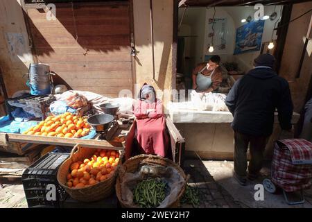 Alter Mann, der Obst und Gemüse auf dem Straßenmarkt Souk in der Stadt Fes in Marokko verkauft. Lokale Geschäfte auf der Straße. Stockfoto