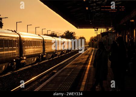 Aufgehende Sonne leuchtet von einem Zug der Chiltern Railways MK3 am Bahnhof Bicester Nord Stockfoto