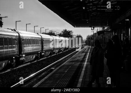 Aufgehende Sonne leuchtet von einem Zug der Chiltern Railways MK3 am Bahnhof Bicester Nord Stockfoto