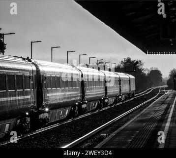 Aufgehende Sonne leuchtet von einem Zug der Chiltern Railways MK3 am Bahnhof Bicester Nord Stockfoto