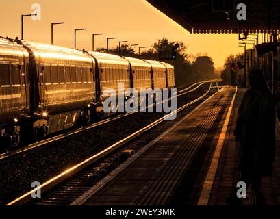 Aufgehende Sonne leuchtet von einem Zug der Chiltern Railways MK3 am Bahnhof Bicester Nord Stockfoto