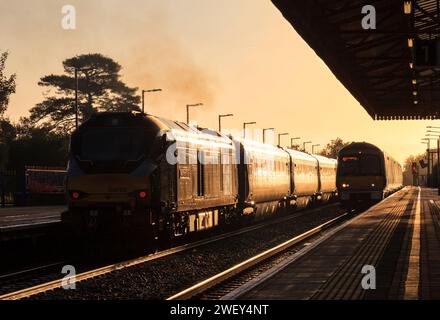 Chiltern Railways der Baureihe 68 Lokomotive 68013 und Baureihe 168 168002 am Bahnhof Bicester North, wo sie die aufgehende Sonne mit einem goldenen Glanz erstrahlen lassen Stockfoto