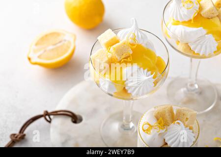 Zitronenkuchen mit Pfund-Kuchen, Zitronenquark, Schlagsahne und Meringue in Coupé-Gläsern Stockfoto