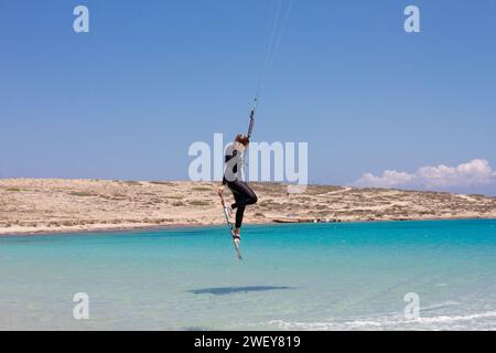 Kitesurfer fliegen ein paar Meter über dem kristallklaren türkisfarbenen Wasser am Strand von Pori auf der Insel Koufonisi, Griechenland, Europa. Stockfoto