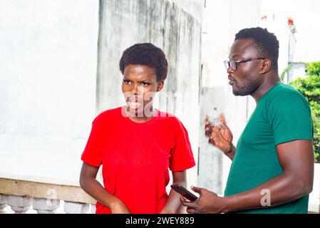 Nettes, nettes, junges afro-amerikanisches Paar, das sich auf dem Balkon des Hauses unterhält. Stockfoto
