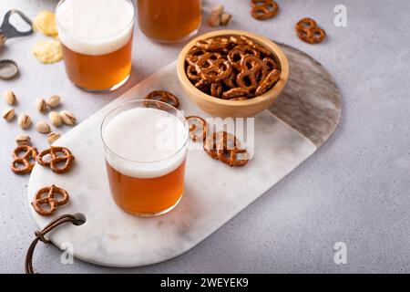Lagerbier oder Ale auf dem Tisch mit salzigen Snacks, Brezeln und Chips Stockfoto