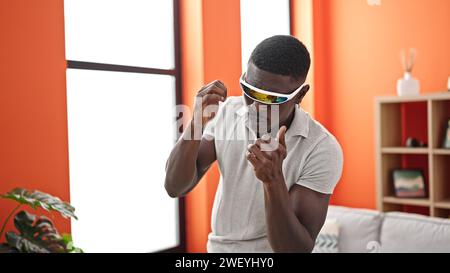 afroamerikaner, der eine Virtual-Reality-Brille benutzt und zu Hause Boxvideospiel spielt Stockfoto