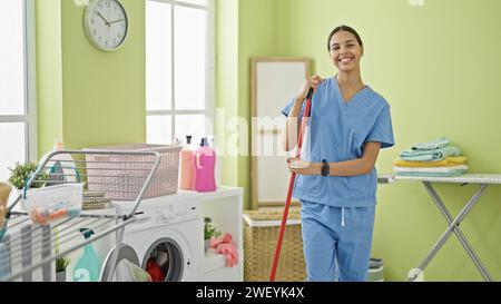 afroamerikanerin, professionelle Reinigungskraft, lächelt in der Waschküche Stockfoto
