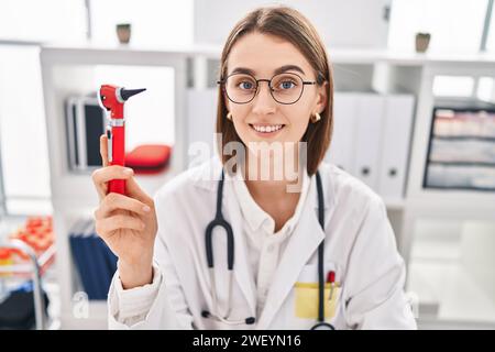 Junge Kaukasierin, die Otoskop in der Klinik hält Stockfoto