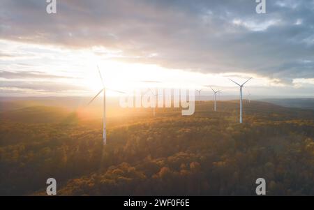 Vogelperspektive von Windturbinen in den Bergen unter bewölktem Himmel bei Sonnensetin deutschland Stockfoto