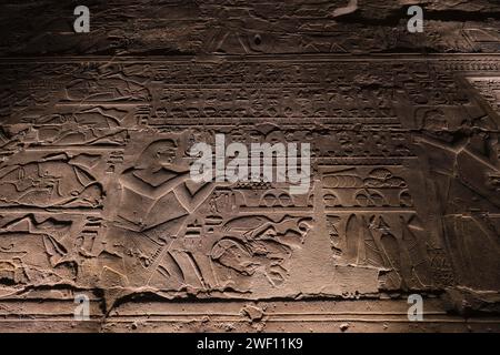Luxor, Ägypten - 26. Dezember 2023: BAS-Reliefs auf beleuchteten Wänden des Luxor-Tempels bei Nacht Stockfoto