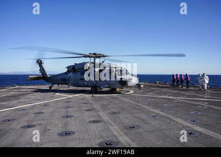 Die Seeleute bereiten sich darauf vor, eine SH-60S Seahawk, die an der Helicopter Sea Combat Squadron (HSC) 23 befestigt ist, auf dem Flugdeck des Amphibien-Dock-Landungsschiffes USS Harpers Ferry (LSD 49) zu tanken, während sie am 11. Januar 2024 im Pazifischen Ozean unterwegs sind. Die Boxer Amphibious Ready Group, bestehend aus USS Boxer (LHD 4), USS Somerset (LPD 25) und Harpers Ferry, und die eingestiegene 15th Marine Expeditionary Unit führen integrierte Trainings- und Routineoperationen in der 3rd Fleet durch. (Foto der US Navy von Mass Communication Specialist 2nd Class sang Kim) Stockfoto