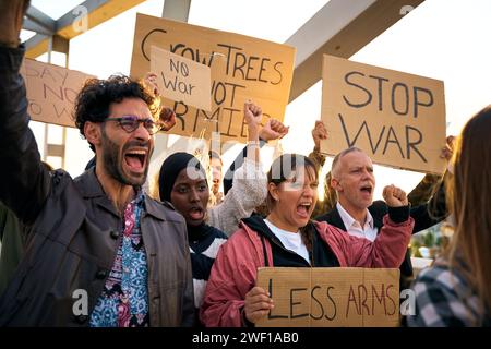 Menschen aus verschiedenen Rassen, die gegen Krieg und Gewalt in der Welt protestieren. Gruppe von Aktivisten Stockfoto