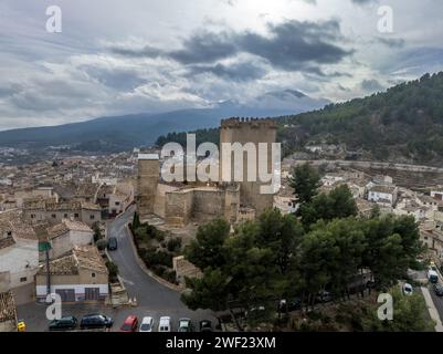 Aus der Vogelperspektive auf das Schloss Moratalla in der Provinz Murcia, Spanien, das das Dorf mit einem großen quadratischen Turm und einem schön restaurierten Denkmal aus dem Mittelalter dominiert Stockfoto