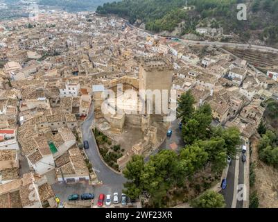 Aus der Vogelperspektive auf das Schloss Moratalla in der Provinz Murcia, Spanien, das das Dorf mit einem großen quadratischen Turm und einem schön restaurierten Denkmal aus dem Mittelalter dominiert Stockfoto