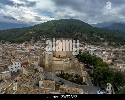 Aus der Vogelperspektive auf das Schloss Moratalla in der Provinz Murcia, Spanien, das das Dorf mit einem großen quadratischen Turm und einem schön restaurierten Denkmal aus dem Mittelalter dominiert Stockfoto