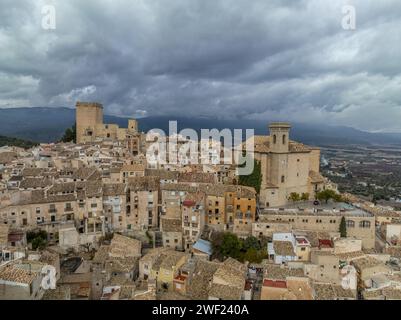 Aus der Vogelperspektive auf das Schloss Moratalla in der Provinz Murcia, Spanien, das das Dorf mit einem großen quadratischen Turm und einem schön restaurierten Denkmal aus dem Mittelalter dominiert Stockfoto