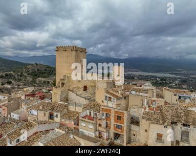 Aus der Vogelperspektive auf das Schloss Moratalla in der Provinz Murcia, Spanien, das das Dorf mit einem großen quadratischen Turm und einem schön restaurierten Denkmal aus dem Mittelalter dominiert Stockfoto