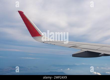 Wing Soaring: Luftperspektiven aus dem Flugzeugfenster, die das riesige Himmelspanorama und das Erdpanorama enthüllen. Die Perspektive fängt die Schönheit des Erdgeländes ein Stockfoto