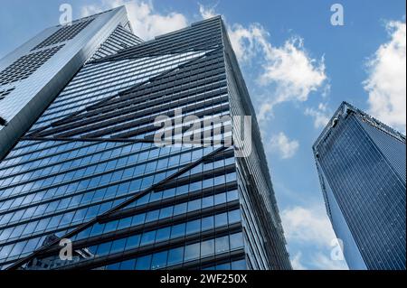 Singapur, 24. Januar 2024: Wolkenkratzer, Symbole der globalen Wirtschaft, erheben sich gegen blauen Himmel und Wolken. Hoch aufragende Strukturen verkörpern die Dominanz des Unternehmens Stockfoto