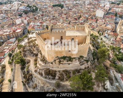 Blick aus der Vogelperspektive auf Petrer, mittelalterliche Stadt und Burg auf einem Hügel mit restauriertem Turm und Zinnen in der Nähe von Elda Spanien, Stockfoto