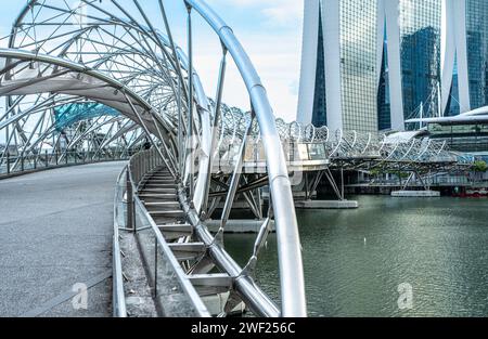 Singapur, 24. Januar 2024: Helix Bridge mit Blick auf Marina Bay Sands, moderne Architektur und berühmte Skyline. Die Brücke überspannt die Bucht, Highlight Stockfoto