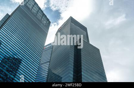 Singapur, 24. Januar 2024: Wolkenkratzer, Symbole der globalen Wirtschaft, erheben sich gegen blauen Himmel und Wolken. Hoch aufragende Strukturen verkörpern die Dominanz des Unternehmens Stockfoto