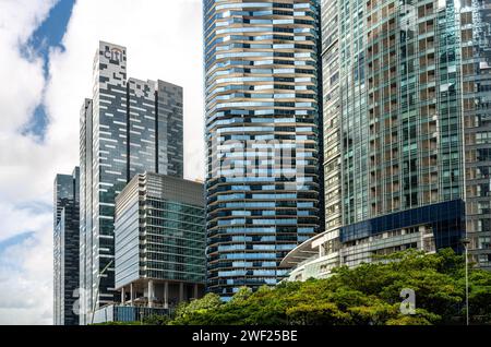 Singapur, 24. Januar 2024: Wolkenkratzer, Symbole der globalen Wirtschaft, erheben sich gegen blauen Himmel und Wolken. Hoch aufragende Strukturen verkörpern die Dominanz des Unternehmens Stockfoto