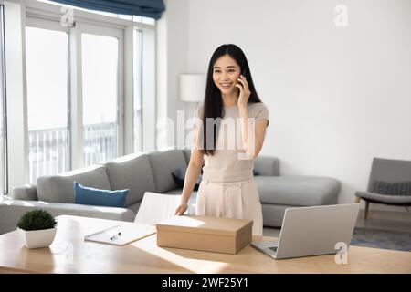 Glückliche junge asiatische Verbraucherfrau, die im Internet-Shop gekauft wird Stockfoto