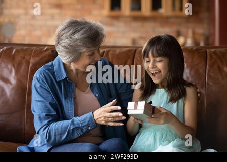 Kleines lateinisches Mädchen schreien vor Freude, erhalten Geschenk von Oma Stockfoto