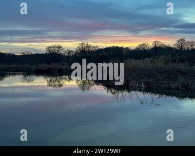 Station Lane, Milford. Januar 2024. Ein schöner Ausklang des Tages für die Home Counties mit trockenem, kaltem und leicht bewölktem Wetter. Sonnenuntergang über Marsh Farm Fisheries in Milford, Surrey. Quelle: james jagger/Alamy Live News Stockfoto