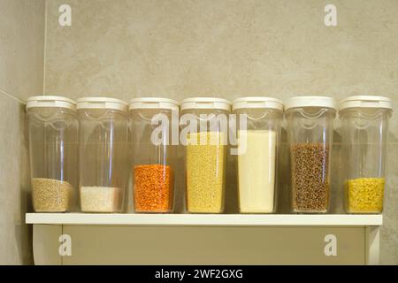 Dosen mit Getreide, Brei und Mehl auf ein Küchenregal stellen Stockfoto