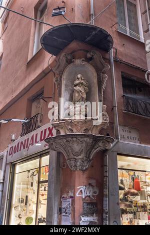 Skulptur der Jungfrau Maria mit Baldachin an einem Eckhaus im historischen Zentrum von Genua, Italien Stockfoto