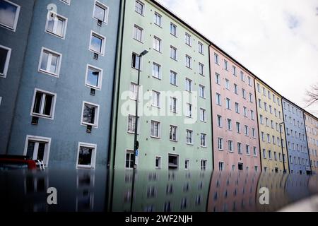 München, Deutschland. Januar 2024. Wohngebäude in verschiedenen Farben spiegeln sich im Dach eines geparkten Autos am 25.01.2024 im Stadtteil Au-Haidhausen in München (Bayern) wider. Quelle: Matthias Balk/dpa/Alamy Live News Stockfoto