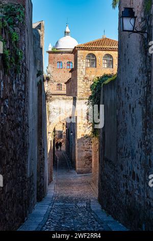 Ein paar Touristen, die durch die engen Gassen der mittelalterlichen Stadt Caceres schlendern Stockfoto