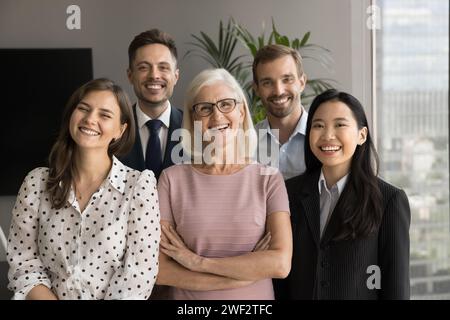 Glückliche ältere Anführerin und Kollegen, die in die Kamera schauen Stockfoto