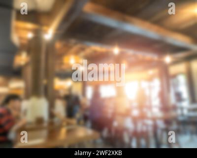 Abstraktes, verschwommenes Restaurant, Holzgebäude Hintergrund, warmes Licht Innencafe oder Club mit Fenster und Sonnenlicht von außen. Verschwommenes Hintergras Stockfoto