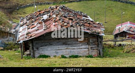 Zinndächer in TrabOn, Türkei, werden mit Felsen heruntergehalten, um zu verhindern, dass starke Winde das Dach abblasen. Stockfoto