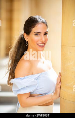 Glückliche, schöne Frau, die draußen in die Kamera schaut Stockfoto