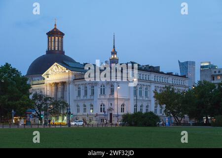 Warschau, Polen - 08. Juni 2019: Die nationale Kunstgalerie Zachęta neben der Dreifaltigkeitskirche in der Abenddämmerung. Stockfoto